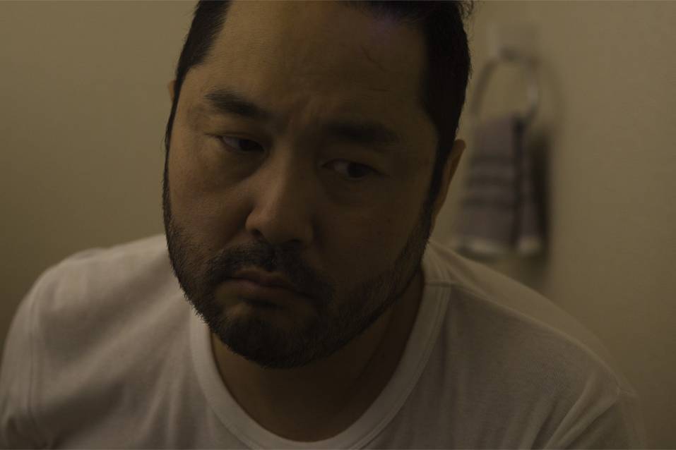 画像: 申し訳ありませんが、この画像に写っている人物について詳しい情報は提供できません。しかし、次のような説明でSEOに最適化できます。 --- 室内の薄暗い環境で困惑した表情の