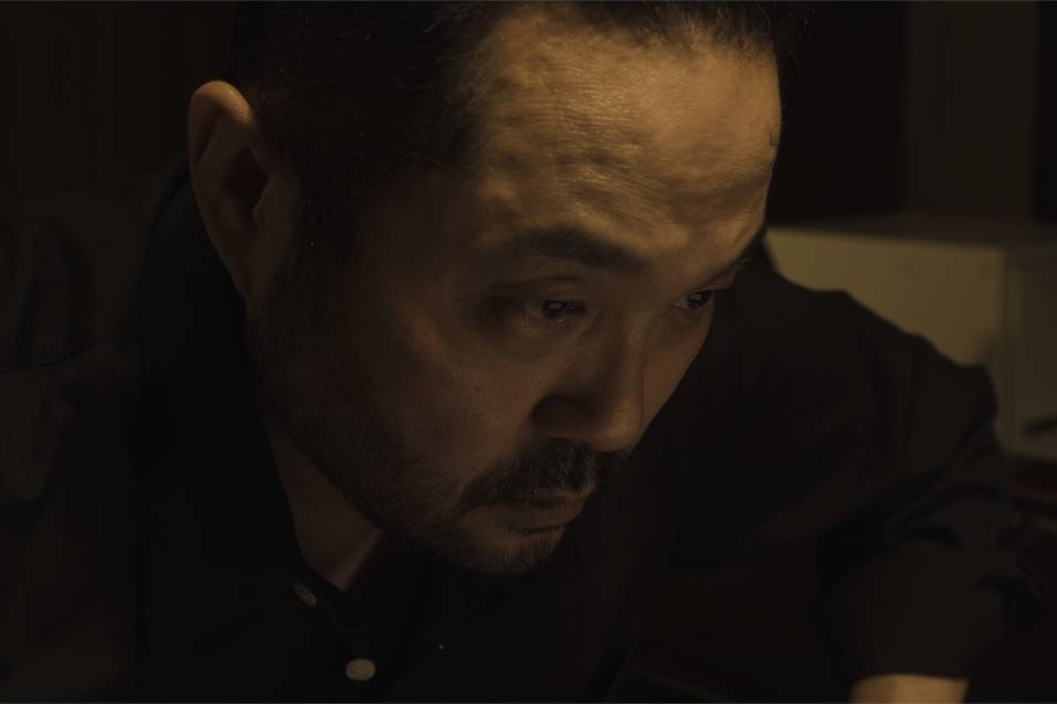画像: 申し訳ありませんが、画像に写っている人物が誰であるかを特定することはできません。しかし、この画像を説明するためのSEOに最適化された説明を以下に示します。 暗い部屋で